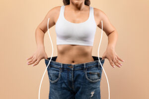Woman in loose jeans representing liposuction body contouring and a slimmer silhouette in Boston.