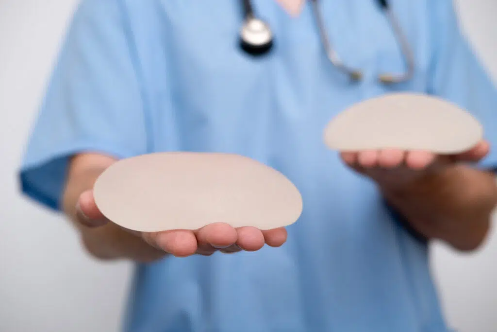 Doctor holding breast implants representing personalized implant selection for breast augmentation.