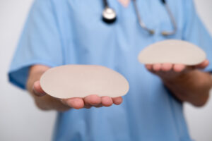 Doctor holding breast implants representing personalized implant selection for breast augmentation.