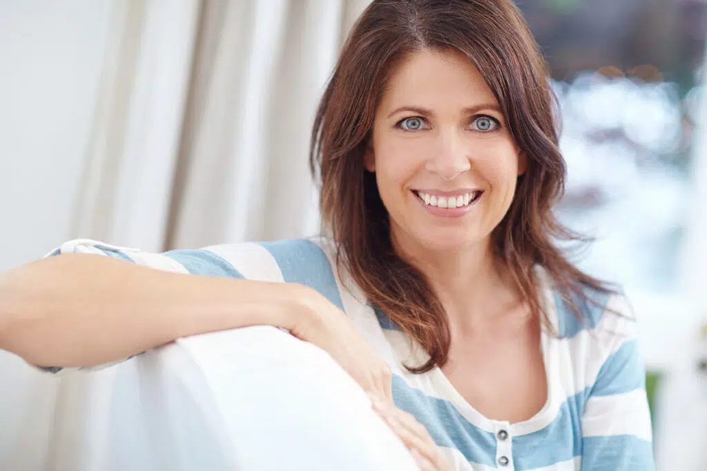 Smiling woman representing Kybella injections for reducing double chin fat without surgery.