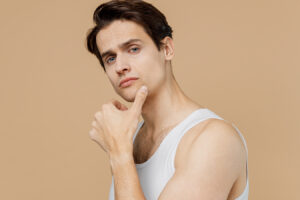 Man touching his chin, representing Kybella treatment for men seeking to reduce double chin fat.