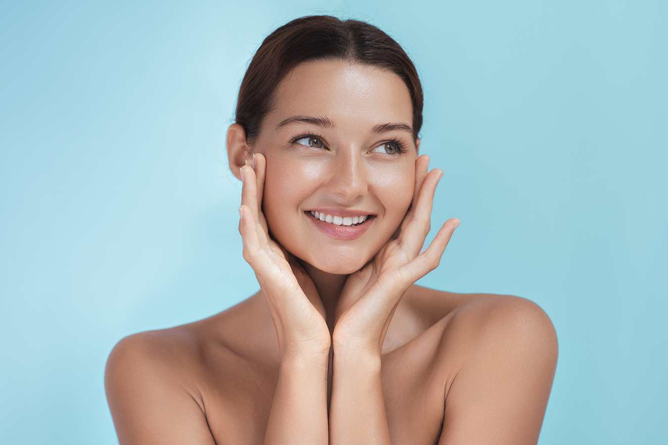 Smiling woman with glowing skin representing lip fillers for a fuller, balanced, natural-looking pout.