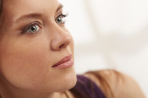 Woman with clear skin highlighting fall facial treatments for sun damage and texture.