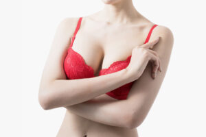 Woman in red bra after breast augmentation, representing recovery and post-surgery care.