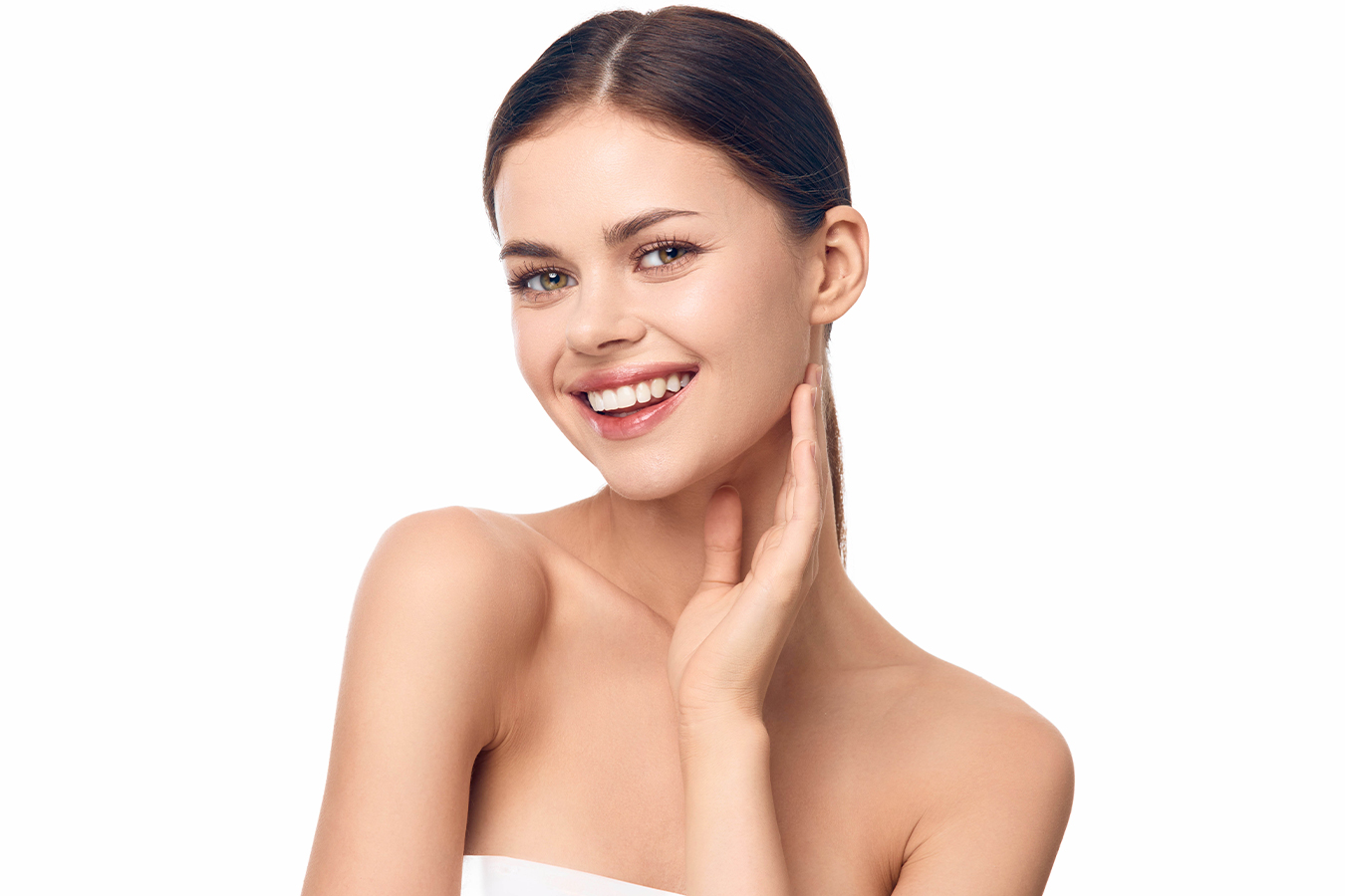 Smiling woman touching her face, highlighting earlobes as a subtle sign of aging.