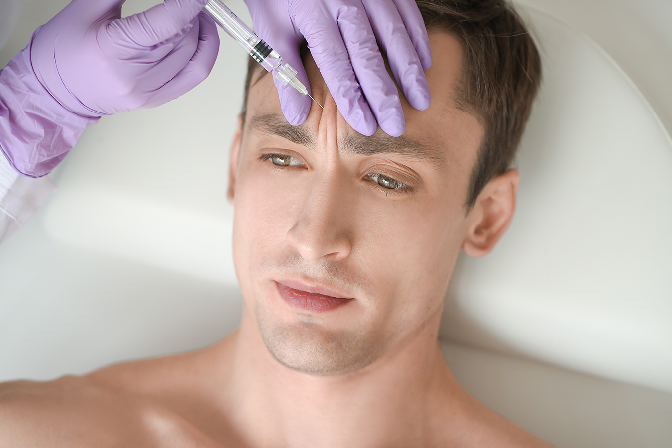 Man receiving forehead Botox injections, representing Bro-tox treatment for fine lines and wrinkles.