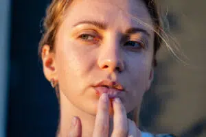 Woman touching face for Botox units and wrinkle treatment guidance.