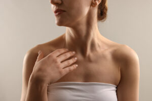 Woman touching neck for neck lift surgery and loose skin treatment information