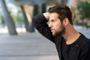Stylish bearded man outdoors representing popular male plastic surgery procedures and rejuvenation.