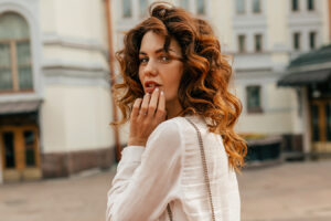 Woman touching lips for lip augmentation filler options and treatment information.