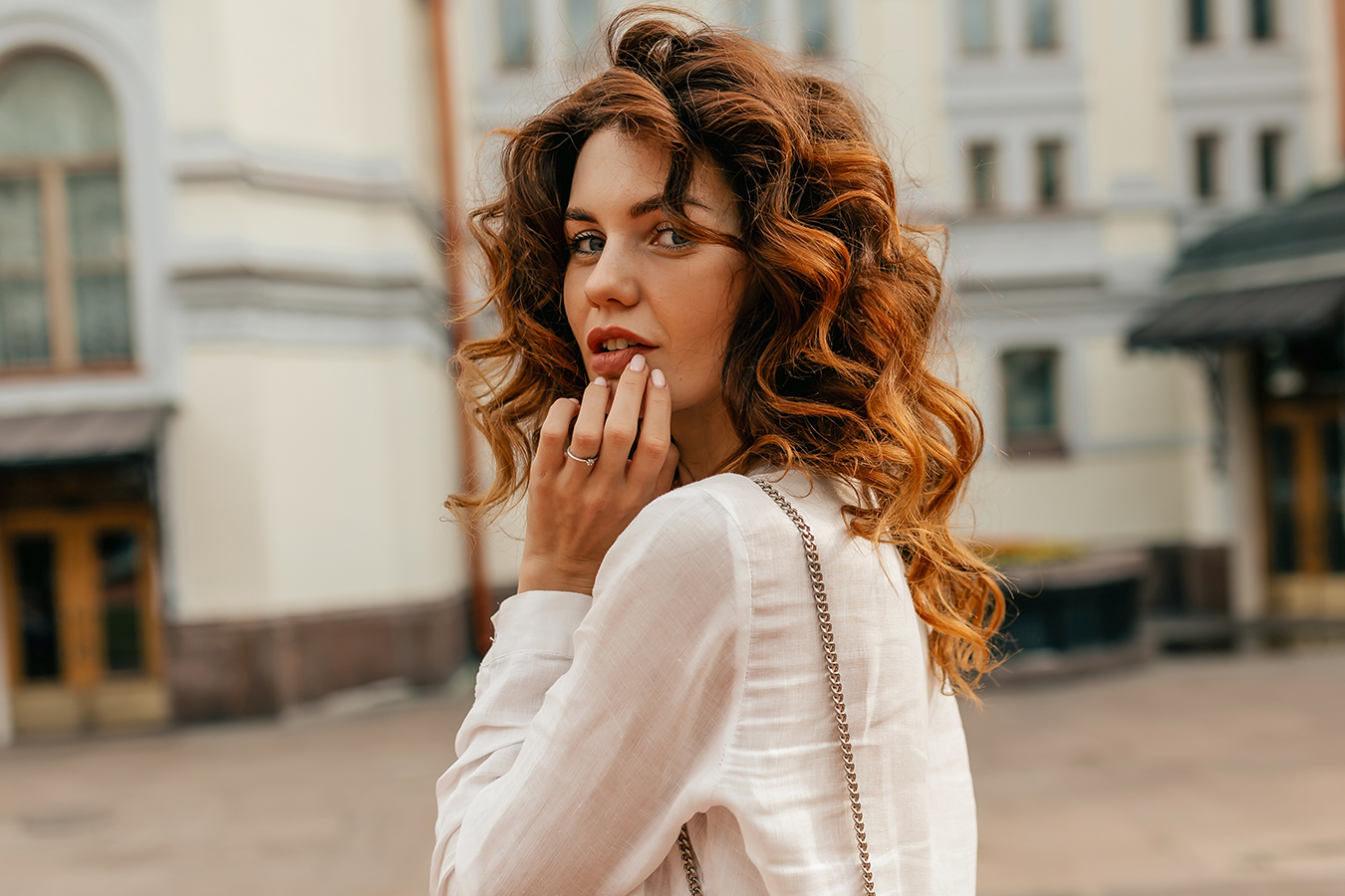 Woman touching lips for lip augmentation filler options and treatment information.
