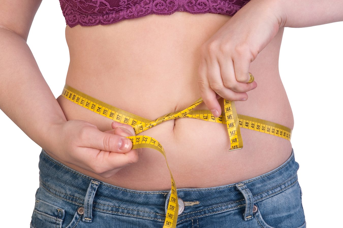 Woman measuring lower belly fat, illustrating surgical and non-surgical options for stubborn fit fat.