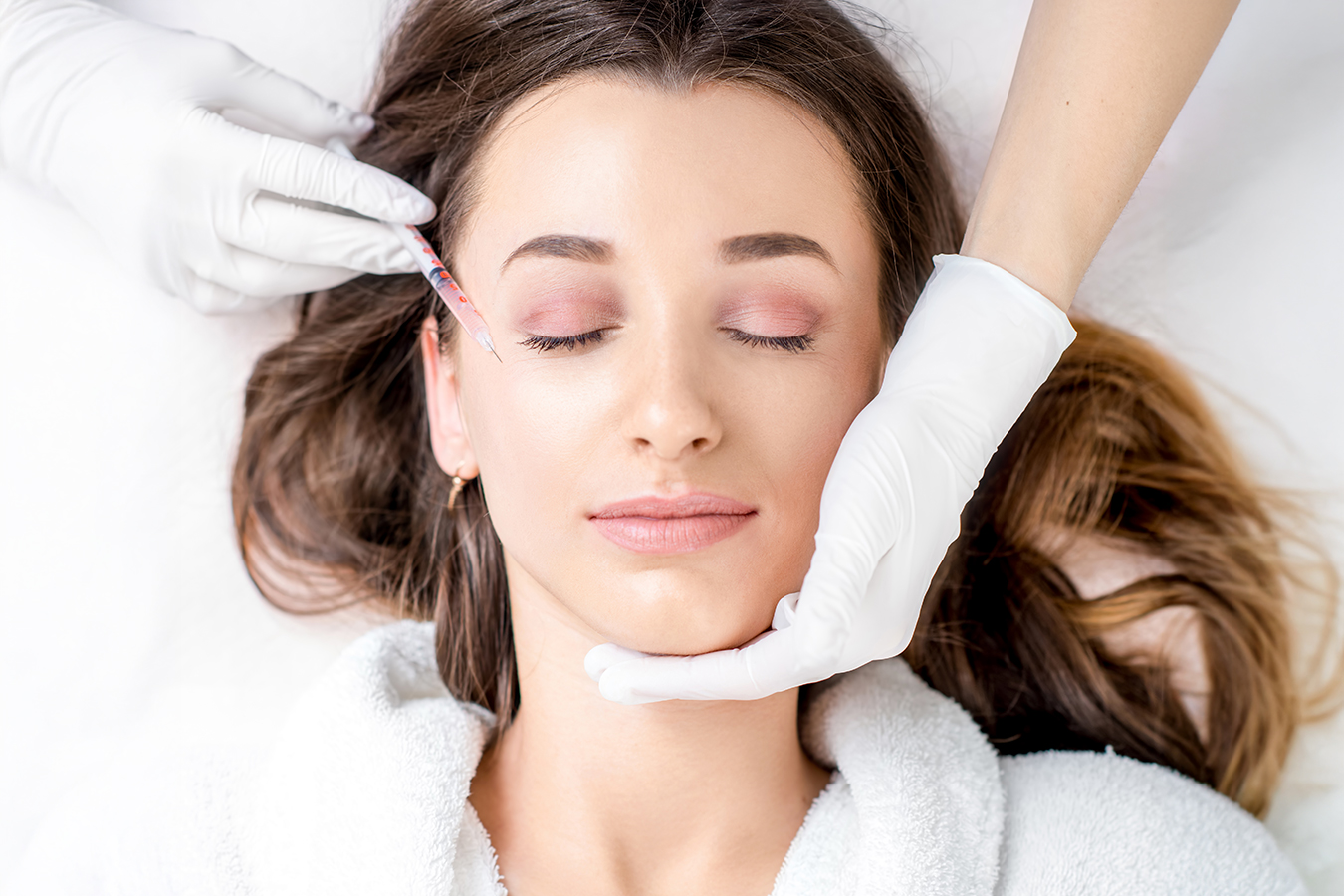 Woman receiving a facial injection representing Juvederm Voluma, Volbella, and Vollure dermal fillers.
