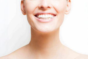 Close-up of a smooth neck and smile, highlighting treatments for neck aging and skin rejuvenation.