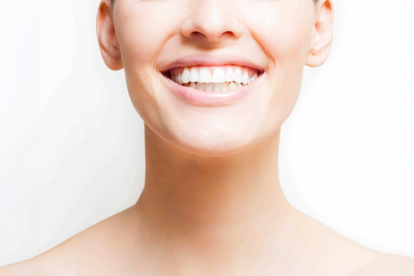 Close-up of a smooth neck and smile, highlighting treatments for neck aging and skin rejuvenation.