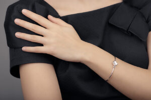 Woman touching her shoulder, highlighting smooth hands and treatment options for age-related changes.