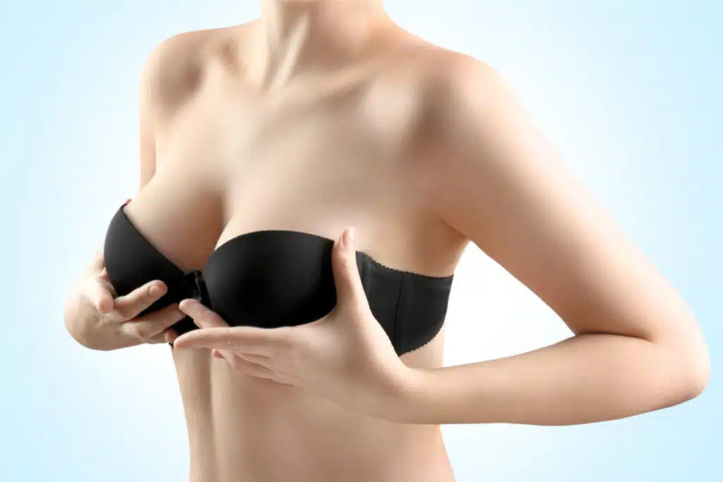 Woman holding black bra illustrating natural shape from Memory Gel Boost™ implant.