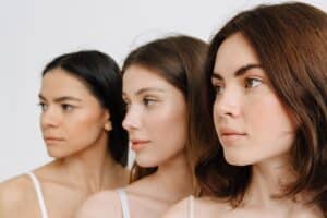 Three young women with clear skin, highlighting lifestyle choices for maintaining youthful skin and optimum rejuvenation in their 20s.