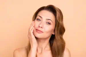 Smiling middle-aged woman with healthy skin, showcasing the results of effective aesthetic treatments for aging in the 40s.