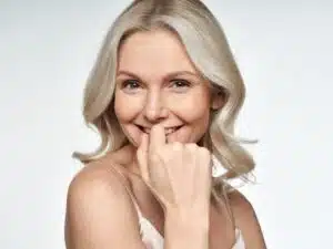 Smiling mature woman with healthy skin, embracing beauty in her 60s with subtle skincare adjustments for hydration and glow.