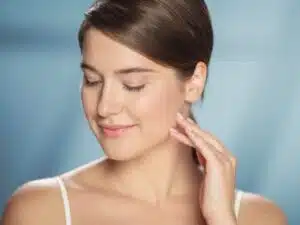Woman with radiant, hydrated skin smiling gently, highlighting tips for achieving a holiday-ready glow.