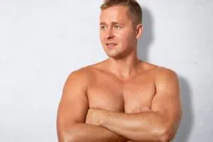 Muscular man with enlarged chest tissue illustrating gynecomastia and hormonal imbalance in men